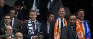 Le Président Macron dans les tribunes du Stade de France, regarde France-Hollande, à droite, avec une barbe, son Premier Ministre, M. (son nom m'échappe)